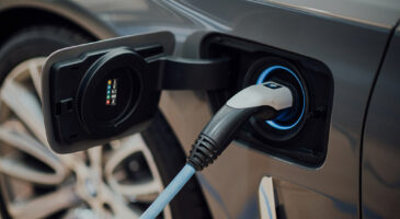 Photo d&rsquo;une voiture &eacute;lectrique connect&eacute;e &agrave; une borne de recharge